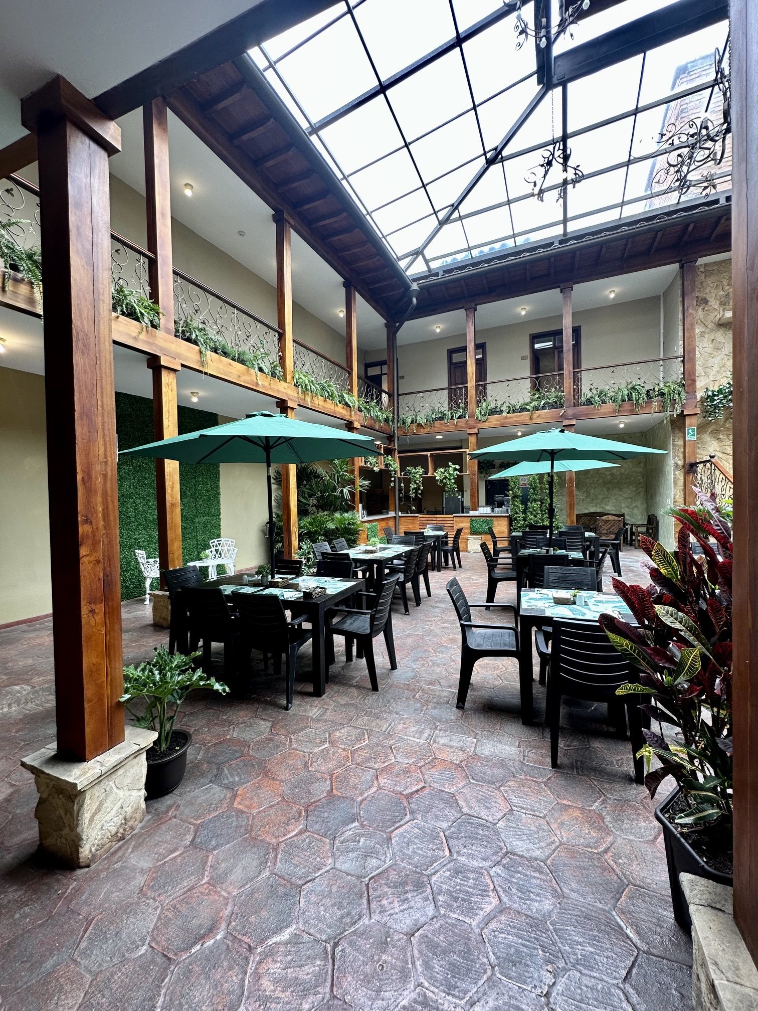 Patio of Hotel NASS Central Garden at dusk with tables, flowers and warm atmosphere