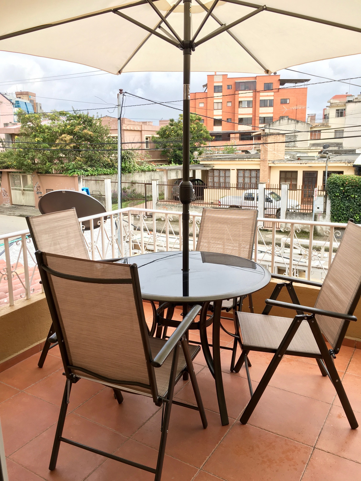 Terrace with table and umbrella at NASS Bed & Breakfast, overlooking the neighbourhood facing Parque de la Madre, Cuenca