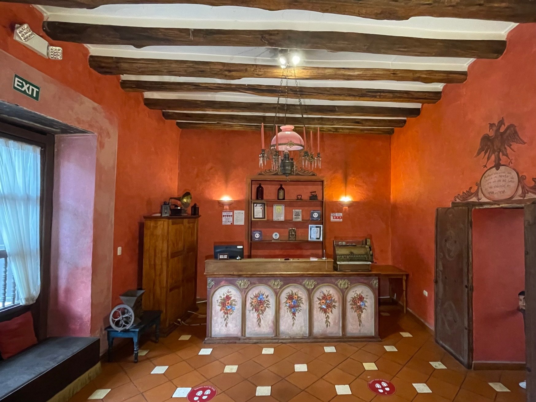Reception of Hotel NASS Casa del Águila with eagle crest on the wall, original wooden beams and hand-painted desk — Historic Center of Cuenca